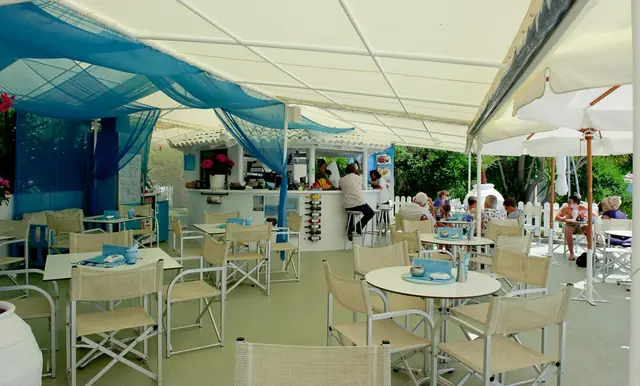 The beach bar under its white canopy and blue drapes