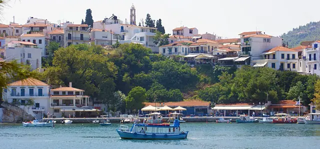 Skiathos old town above the harbour, a caique in the water